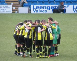 The Burton players huddle up before kick off