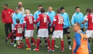 The opposition players shake hands before the game