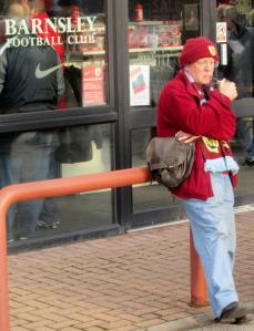 A Burnley fan smokes his pipe outside the stadium
