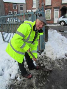 Chesterfield supporter Jeff Hall helps to clear the snow in the car park