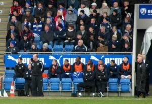 Paul Cook looks on from the home dugout