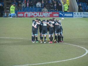 Aldershot huddle up before the game gets underway
