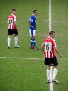 The Exeter defence keep a close eye on Lester