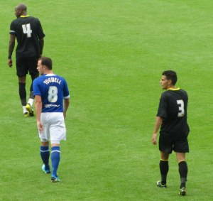 Sam Togwell is closely marked by Gardner and Floro