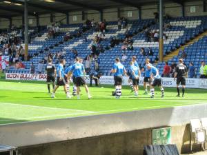 The visiting players warm up ahead of the first game of the new season