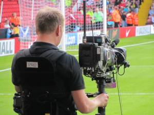 A cameraman on the touchline