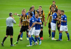 The referee attempts to calm the players down