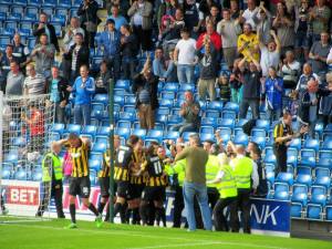 The players and fans celebrate the goal