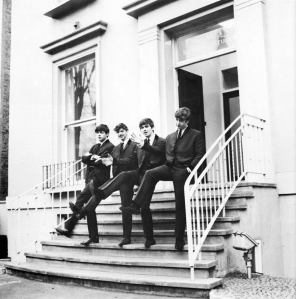 A publicity photo of The Beatles on the steps in 1962