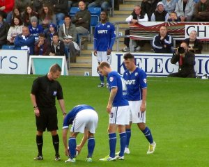 The players stand over a free kick