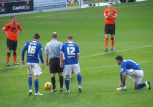 Devitt, Ryan and Roberts stand over a free kick