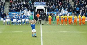 The teams line up on the field