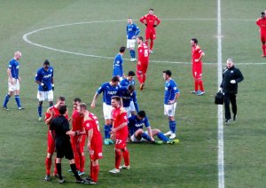 The referee shows Danny Mayor a red card for a foul on Matty Brown