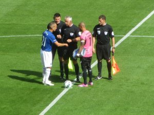 The officials and the two captains exchange handshakes