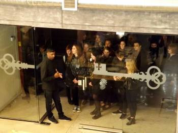 The first few fans wait to be let through the door